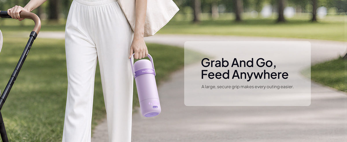 Parent carries the purple warmer by its handle beside a stroller